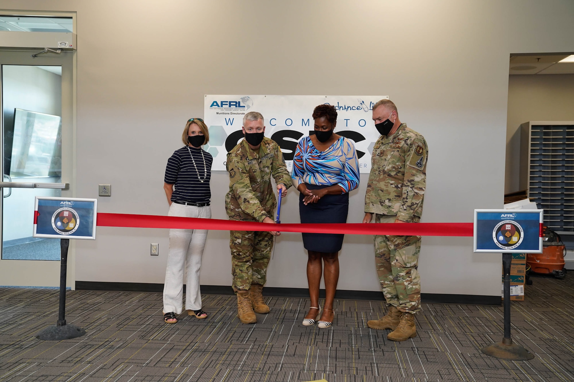 AFRL Munitions Directorate Commander, Col. W. Tony Meeks cuts the ceremonial ribbon for the new Ordnance Science Innovation Center on Eglin AFB, Fla. He is flanked on the left by Integration and Operations Division Chief, Jaime Pinto, and to the right by Ordnance Division Chief, Segrid Harris, followed by former Director, Col Garry Haase. (U.S. Air Force photo/John Leake)