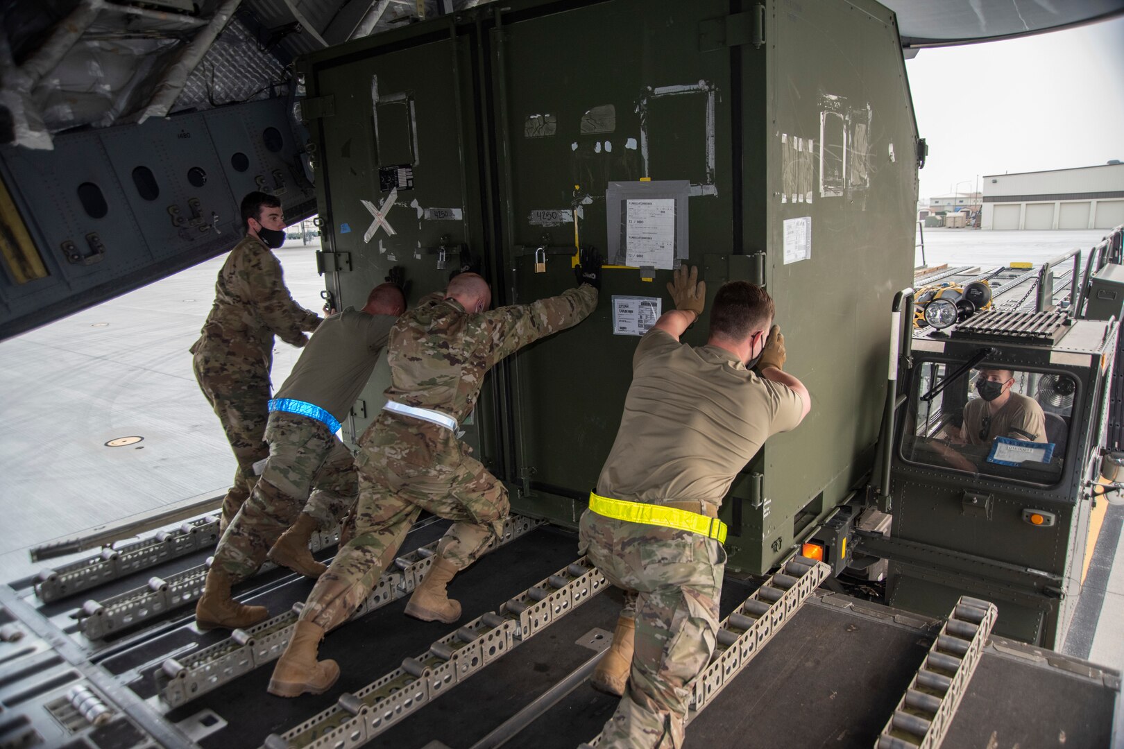 366th Logistics Readiness Squadron Airmen are pushing a ISU-90 to a 60K Tuner trailer.