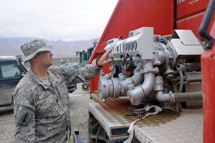 U.S. Army Spc. Travis Hale, a combat engineer with Headquarters and Headquarters Company, 86th Infantry Brigade Combat Team (Mountain), Task Force Wolverine inspects Afghan National Police's firefighting equipment police at the Operations Command Center Aug. 5, 2010, in Bamyan, Afghanistan.