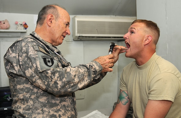 Lt. Col. Thomas Essex, left, a general medical officer with Charlie Company, 186th Brigade Support Battalion, Vermont Army National Guard, looks at 1-178th Field Artillery, South Carolina Army National Guard member, Sgt. Sloan Holley's throat during a check up Aug. 10, 2010, at the troop medical clinic at Camp Phoenix in Kabul, Afghanistan. Essex and other members of Charlie Company provide medical care for service members stationed on Camp Phoenix and other camps throughout the Kabul Base Cluster.