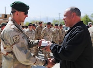 Zoran Konjanovski, the Macedonian minister of defense, shakes the hand of a soldier serving in the Macedonian Embedded Task Force and presents him with a medal during a ceremony welcoming the task force to Afghanistan, April 5. The Macedonian soldiers on the embedded training team will serve with the 86th Infantry Brigade Combat Team, based out of Vermont. Macedonia and Vermont have had a partnership program since 1993, but this is the first time that they have served together in a combat zone.