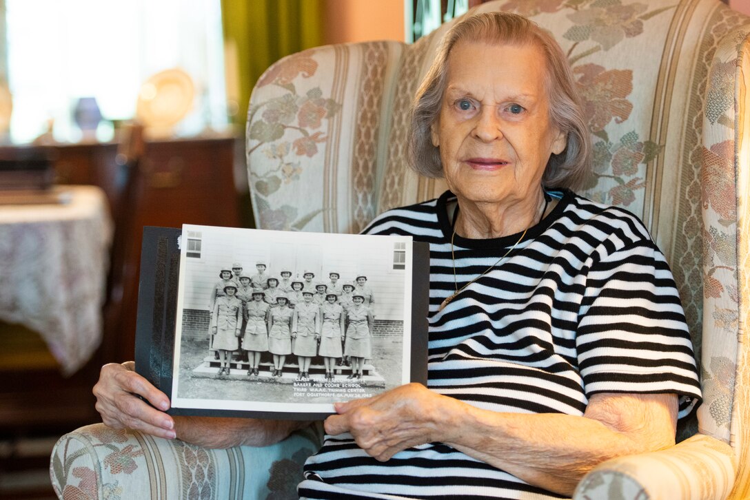 Lorraine Vogelsang, a Women’s Army Corps veteran, poses with a photo of her and her fellow classmates from Bakers and Cooks School at Fort Oglethorpe, Georgia, inside her Cincinnati, Ohio, home, Aug. 19, 2021. Vogelsang served in the WAC from February 1943 until August 1945. (U.S. Air Force photo by Wesley Farnsworth)
