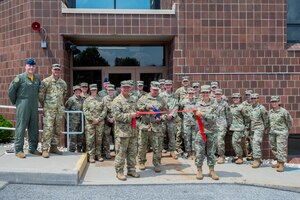 Lt. Col. Gregory S. Sell, 911th Aeromedical Evacuation Squadron commander, cuts a ribbon after a lengthy renovation at the Pittsburgh International Airport Air Reserve Station, Pennsylvania, Aug. 6, 2021. Renovations have been completed on the former 911th Avionics Flight building and will soon be staffed by the 911th AES.