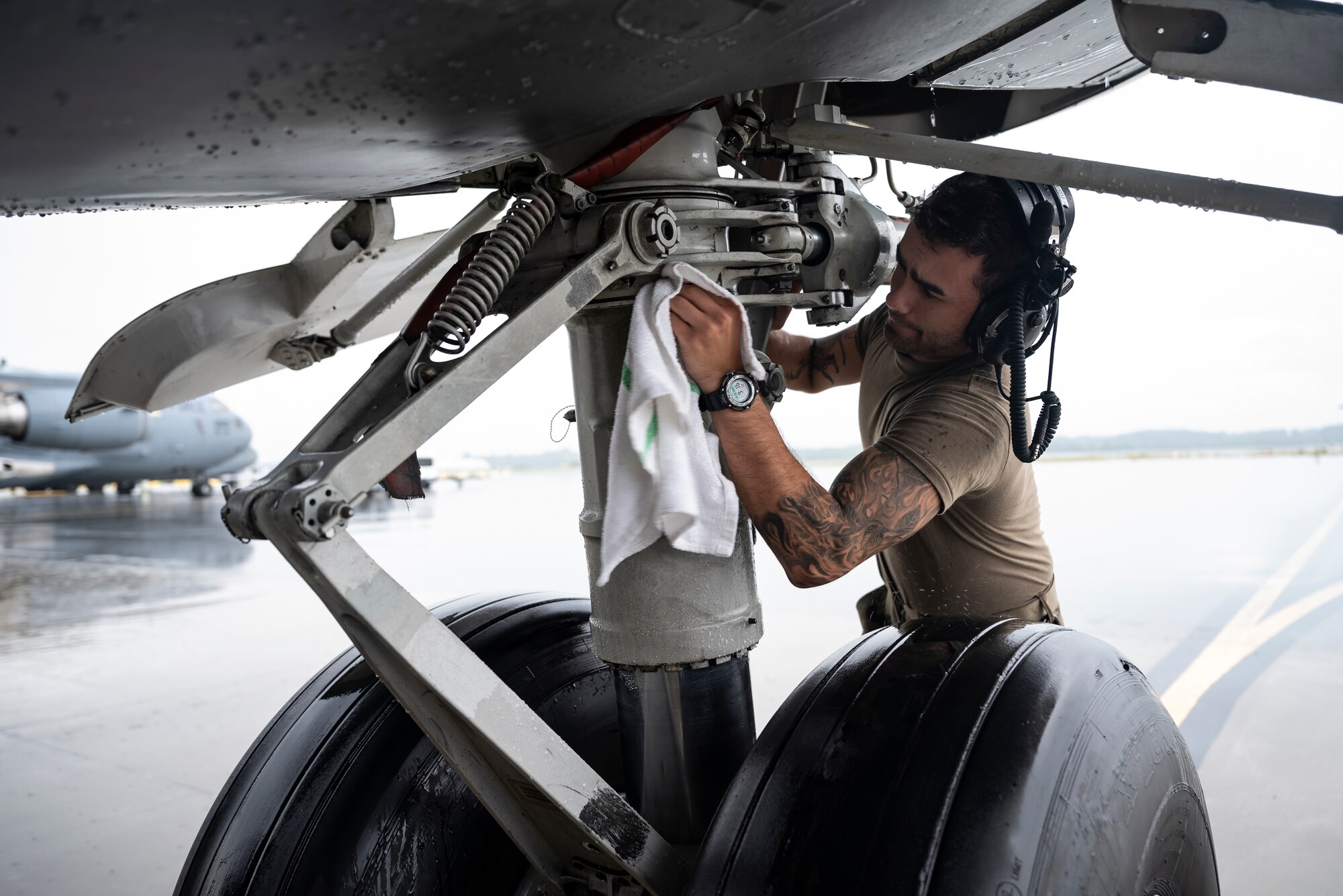 Senior Airman Clayton Roppa, 911th Aircraft Maintenance Squadron crew chief, wipes down the landing gear of a C-17 Globemaster III at the Pittsburgh International Airport Air Reserve Station, Pennsylvania, Aug. 16, 2021. Airmen routinely wipe down a variety of parts of the aircraft to help prevent corrosion.