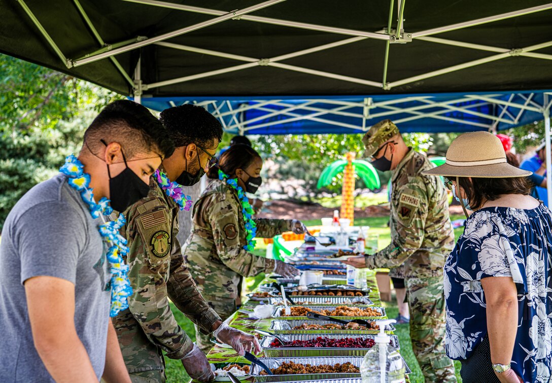 PETERSON SPACE FORCE BASE, Colo. – Volunteers serve food to attendees of the Luau on the Lawn at Peterson Space Force Base, Colorado, Aug. 13, 2021. The Peterson Chapel Team hosted the resiliency event providing a free meal to Airmen, Guardians and their families. (U.S. Space Force photo by Airman 1st Class Joshua Fontenot)