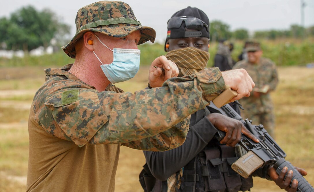 A U.S. Marine with Combined Task Force-68 instructs a member of the Ghanaian Special Boat Squadron (SBS) during a live-fire drill at the Naval Training Command (NAVTRAC) in Nutekpor-Sogakope, Ghana, Aug. 12, 2021. Combined Task Force-68, deployed aboard the USS Hershel “Woody” Williams, conducted Theatre Security Cooperation training with the Ghanaian Special Boat Squadron at NAVTRAC to enhance operational capabilities and readiness throughout Western Africa. (U.S. Marine Corps photo by Sgt. James Bourgeois)