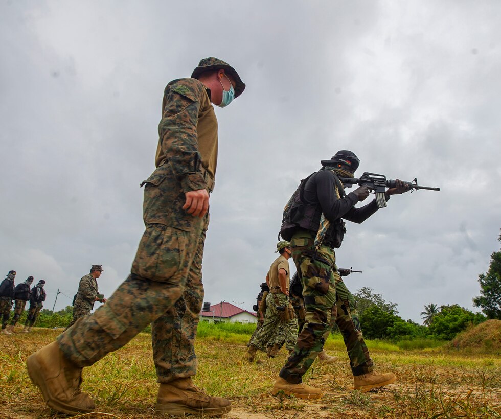 A U.S. Marine with Combined Task Force-68 observes a member of the Ghanaian Special Boat Squadron (SBS) during a live-fire drill at the Naval Training Command (NAVTRAC) in Nutekpor-Sogakope, Ghana, Aug. 12, 2021. Combined Task Force-68, deployed aboard the USS Hershel “Woody” Williams, conducted Theatre Security Cooperation training with the SBS at NAVTRAC to enhance operational capabilities and readiness throughout Western Africa. (U.S. Marine Corps photo by Sgt. James Bourgeois)