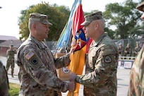 Maj. Gen. Michael Turley, the adjutant general, Utah National Guard, passes the organizational colors to the outgoing commander, Col. Steven A. Fairbourn, during the 65th Field Artillery Brigade change-of-command ceremony Aug. 8, 2021, at Camp Williams, Utah.