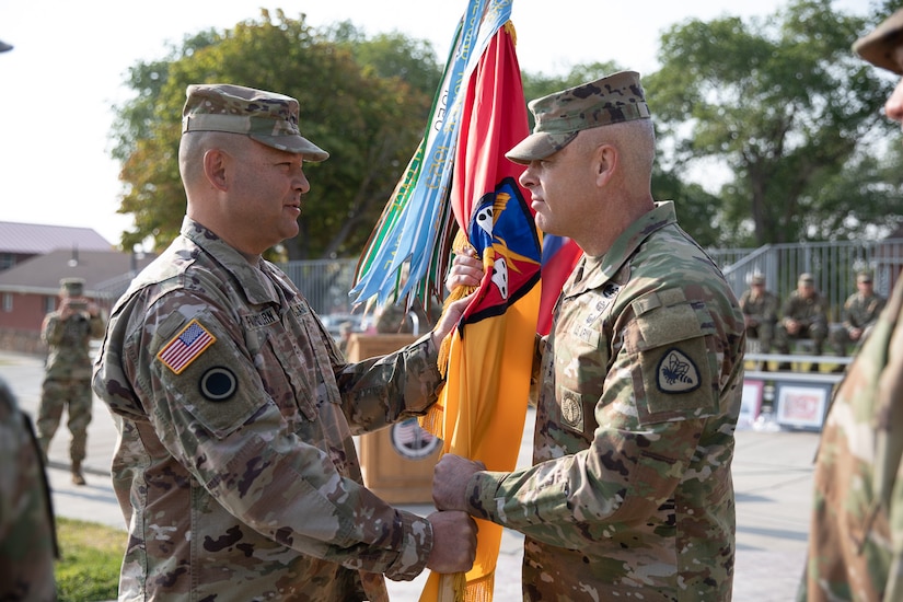 Maj. Gen. Michael Turley, the adjutant general, Utah National Guard, passes the organizational colors to the outgoing commander, Col. Steven A. Fairbourn, during the 65th Field Artillery Brigade change-of-command ceremony Aug. 8, 2021, at Camp Williams, Utah.