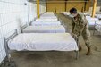 Private 1st Class Jesus Moreno from 16th Sustainment Brigade setting up and arranging beds at the Deployment Processing Center (DPC) on Rhine Ordnance Barracks in Kaiserslautern, Germany August 20th, 2021 in order to support the evacuation of Afghan refugees. The 21st Theater Sustainment Command supports the Department of State in the transportation, housing, and sustainment of U.S. Citizens, Special Immigrant Visa applicants, and other at-risk Afghans who are being evacuated from Afghanistan. (U.S. Army photo by Sgt. Jesse Pilgrim)