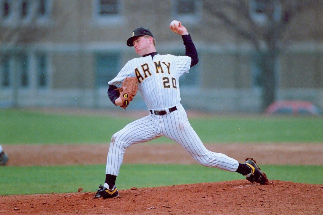 A cadet pitches a baseball.