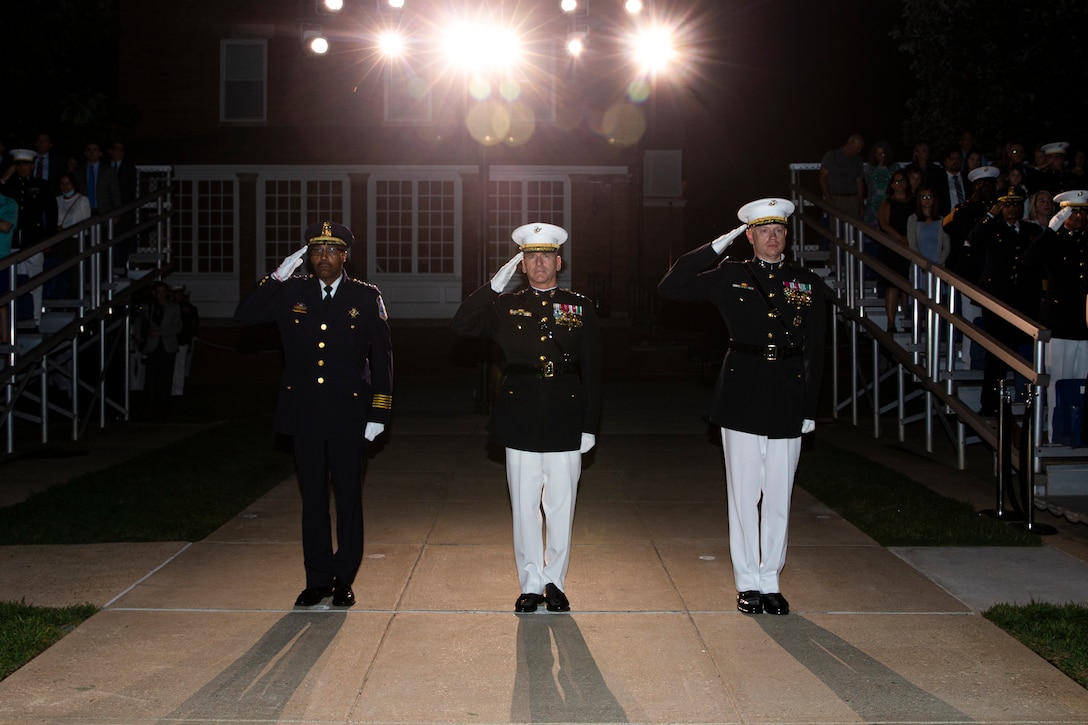 From left, Mr. Robert J. Conte III, Chief of the Metropolitan Police Department, Lt. Gen. David A. Ottignon, Deputy Commandant for Manpower and Reserve, and Col. Teague A. Pastel, commanding officer, Marine Barracks Washington, stand at the position of attention and render a salute during “honors” for the Friday Evening Parade at MBW, Aug 20, 2021. The guest of honor for the evening was Mr. Robert J. Conte III and the hosting official was Lt. Gen. David A. Ottignon. (U.S. Marine Corps photo by Lance Cpl. Allen T. Sanders)
