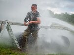 U.S. Air Force Staff Sgt. Adam Roach, 103rd Security Forces Squadron, is sprayed with water while climbing out of a tunnel during the physical training portion of the Connecticut SWAT Challenge in West Hartford, Connecticut, Aug. 19, 2021. The competition brought together tactical operators from across the nation to train on SWAT weapons tactics and physical fitness.