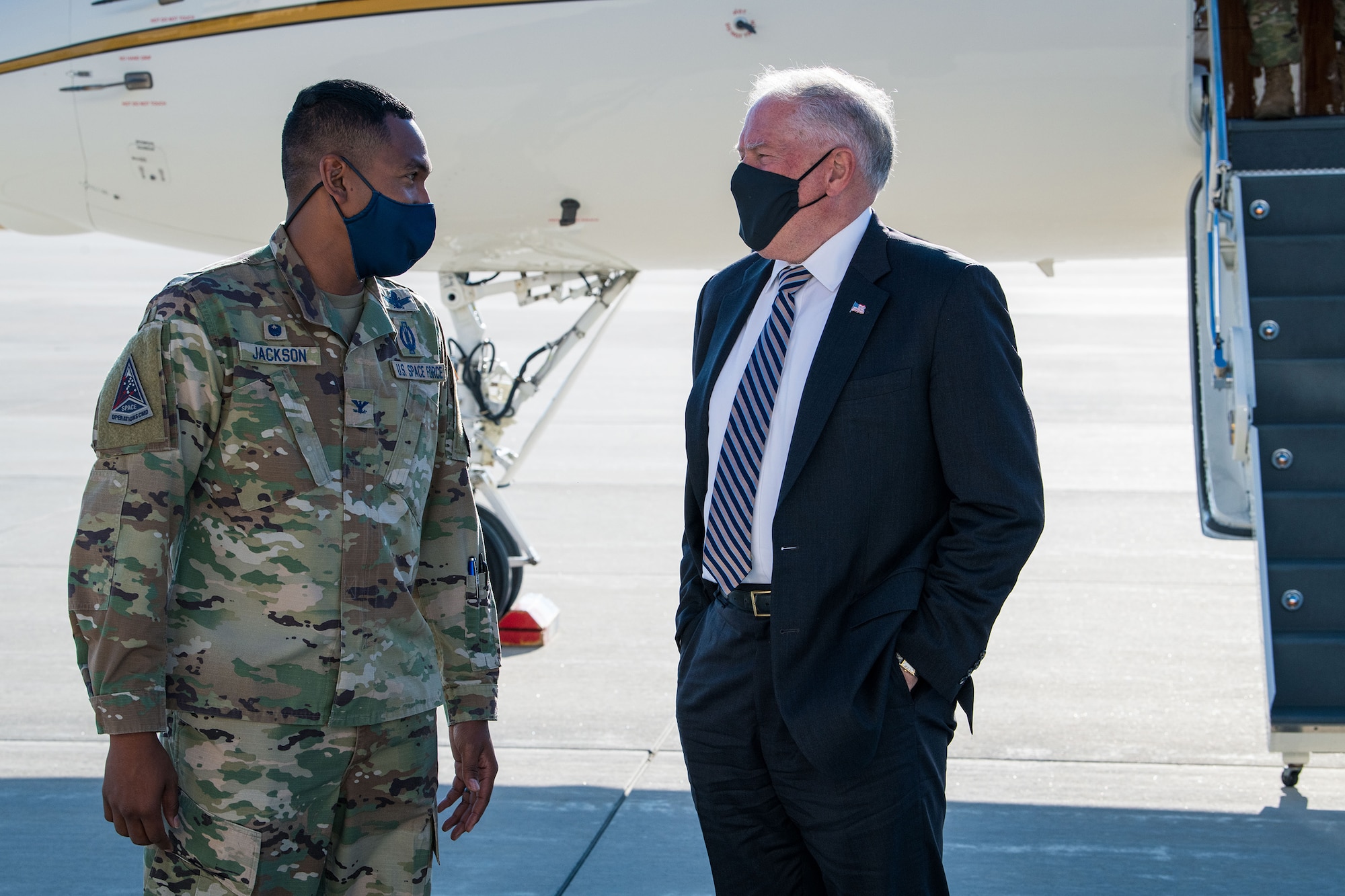 U.S. Space Force Col. Marcus Jackson (left), the Buckley Garrison commander, greets Secretary of the Air Force Frank Kendall on the flightline at Buckley Space Force Base, Colo., Aug. 23, 2021.