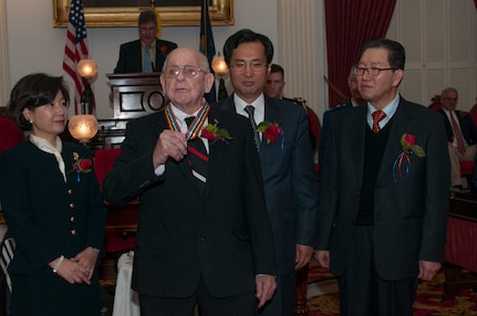 Bruce Cram accepts his medal from the Republic of Korea in honor of his fallen comrade, Lt. Francis W. Escott, in Montpelier, Vt., Nov. 12, 2013. Escott was a pilot with the 158th Fighter Wing, Vermont Air National Guard, and was shot down during his 58th flying mission and taken prisoner. (U.S. Air National Guard photo by Staff Sgt. Sarah Mattison)