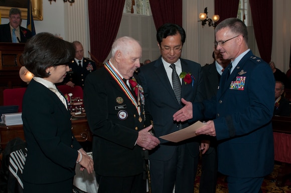 U.S. Air Force Maj. Gen. Steven Cray congratulates Fred Newhall during an awards ceremony being held at the state house in Montpelier, Vt., Nov. 12, 2013. Newhall was one of 28 Vermonters to receive an award from the Republic of Korea, for his service during the Korean War. (U.S. Air National Guard photo by Staff Sgt. Sarah Mattison)