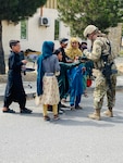 1st Lt. Michelle Jaeger, a platoon leader with the Minnesota National Guard's A Company, 1st Combined Arms Battalion, 194th Armor Regiment, interacts with Afghan children as part of operations at Hamid Karzai International Airport Aug. 21, 2021.   Minnesota Soldiers are providing humanitarian assistance to U.S. citizens, special immigrant visa holders, and their families.