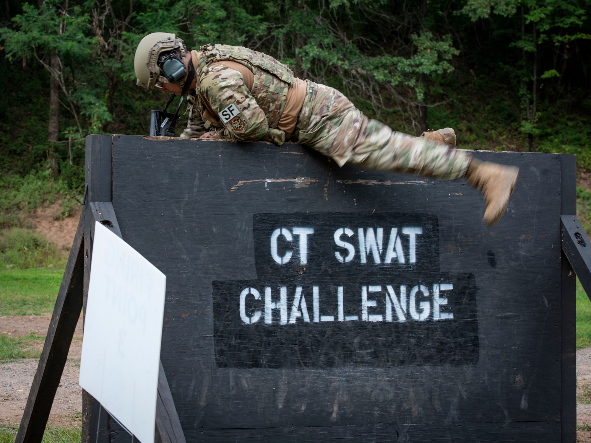 Tech. Sgt. Leo Otero, 103rd Security Forces Squadron, climbs over a wall during the Connecticut SWAT Challenge in East Granby, Connecticut, Aug. 18, 2021. The competition brings together tactical operators from across the nation to train SWAT weapons tactics, movements, and physical fitness. (U.S. Air National Guard photo by Tech. Sgt. Steven Tucker)
