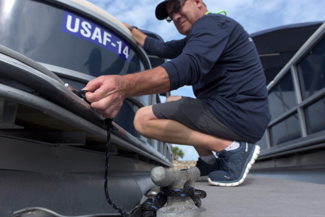Man unties a docked boat
