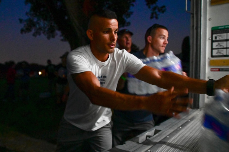 U.S. Space Force Capt. Nicholas Ruiz, Space Delta 9 – Orbital Warfare, 1st Space Operations Squadron director of assessments, exercises and analysis (left) and U.S. Space Force Tech. Sgt. Kristopher Rowell, DEL 9, 1st SOPS future operations section chief help load bottles of water into support vehicles for the Air Force Cycling Team's trip through Iowa at Camp Dodge, Johnston, Iowa, July 26, 2021. RAGBRAI is a noncompetitive cycling event that occurs yearly during the last week of July, organized by The Des Moines Register — the daily morning paper of Iowa’s capital. The first ride occurred in 1973 when Des Moines Register feature writers John Karras and Donald Kaul, both avid cyclists, decided to ride across Iowa and write about it. July 25 – 31 was the 48th RAGBRAI from Le Mars to Clinton, Iowa. (U.S. Air Force photo by Andrew C. Patterson)