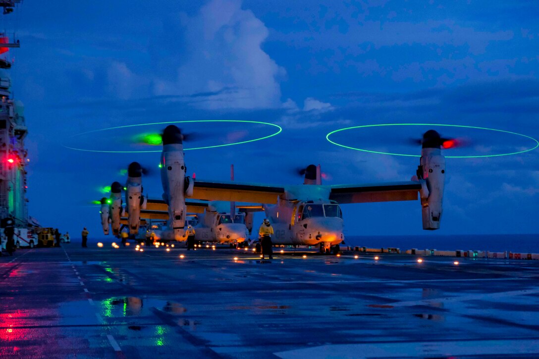 Four Marine Corps aircraft prepare to takeoff from the deck of a ship.