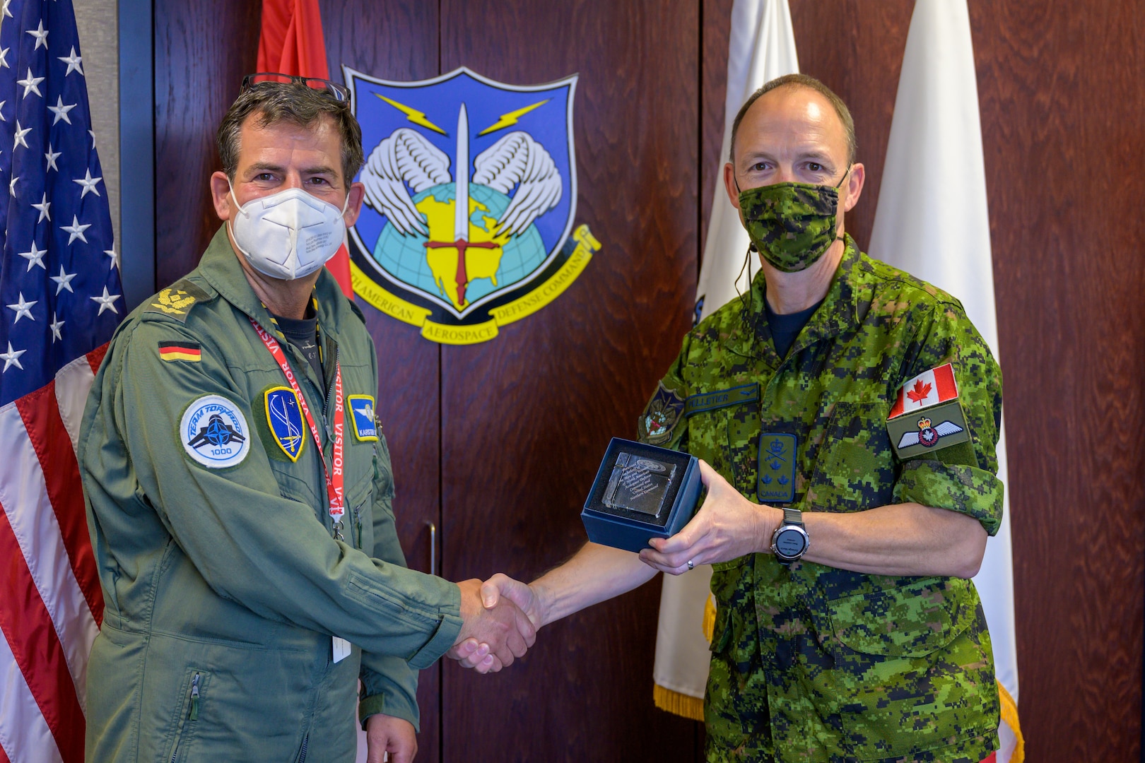 German Air Force Major-General Karsten Stoye, NATO’s Chief of Staff Allied Air Command, exchanges gifts with Royal Canadian Air Force Lieutenant-General Alain Pelletier, Deputy Commander, North American Aerospace Defense Command, during his visit to the NORAD and U.S. Northern Command Headquarters at Peterson Space Force Base, Colorado, Aug. 23, 2021. Stoye traveled to the headquarters to receive information on the Global Information Dominance Experiments and discuss with leadership how NORAD and USNORTHCOM and NATO can collaborate on missile defense.