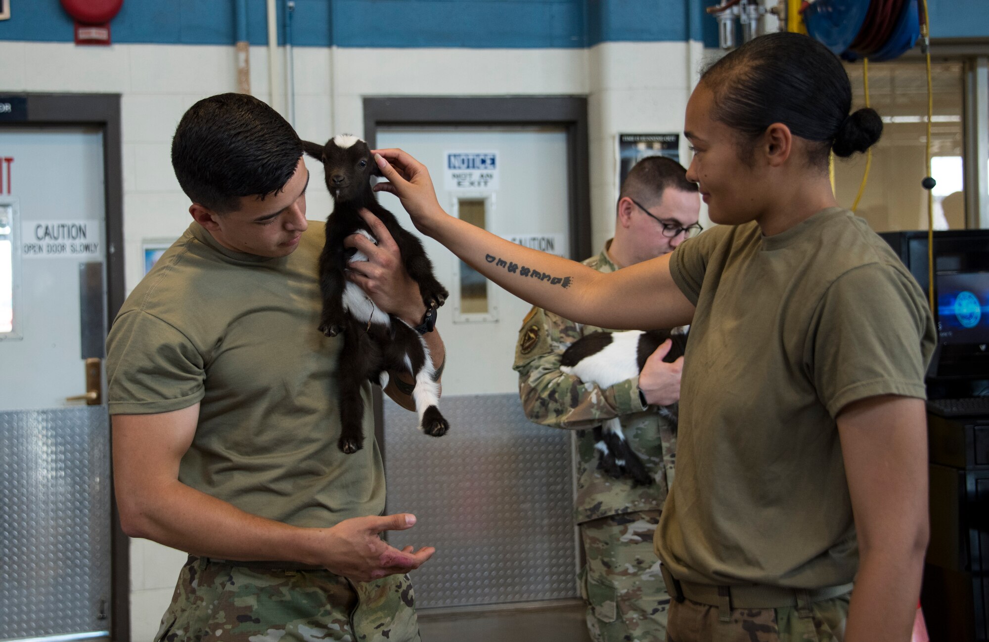 From left, U.S. Air Force Staff Sgt. Jordan Williamson, 97th Logistics Readiness Squadron (LRS) vehicle maintenance journeyman, and U.S. Air Force Airman 1st Class Dominique Bell, 97th LRS fleet management and analysis journeyman, pet a baby goat at Altus Air Force Base, Oklahoma, June 15, 2021. The goats, Ozzy and Cher, are from the 1AB Ranch in Altus, Oklahoma and were born just a few days before they visited the Airmen. (U.S. Air Force photo by Senior Airman Amanda Lovelace)