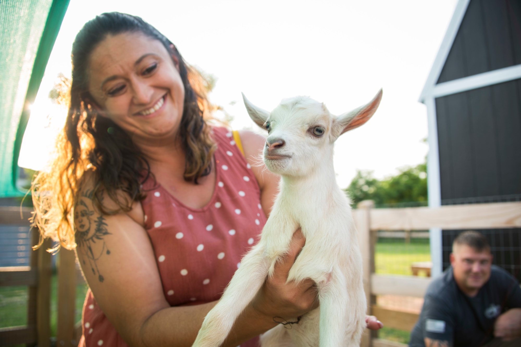 Desiree Kessler, wife of U.S. Air Force Master Sgt. Thomas Kessler, 97th Logistics Readiness Squadron Vehicle Management Flight superintendent, holds a baby goat on 1AB Ranch in Altus, Oklahoma, Aug. 5, 2021. Desiree is a hairstylist and grew up in Arkansas around farm animals. (U.S. Air Force photo by Senior Airman Amanda Lovelace)