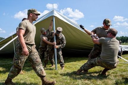 U.S. Marines from Marine Wing Support Squadron 471 and U.S. Air National Guard Airmen from the Volk Field Combat Readiness Training Center (CRTC) work together to raise reception tents for the arrival of Afghans at Volk Field Air National Guard Base, Wisconsin, Aug. 19, 2021.