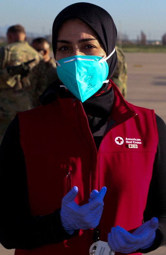Reihaveh Hajibeigi, a representative from the American Red Cross, prepares to aid the passengers coming off the first flight from Kabul Hamid Karzai International Airport at Fort Bliss, Texas, on Aug. 21, 2021.