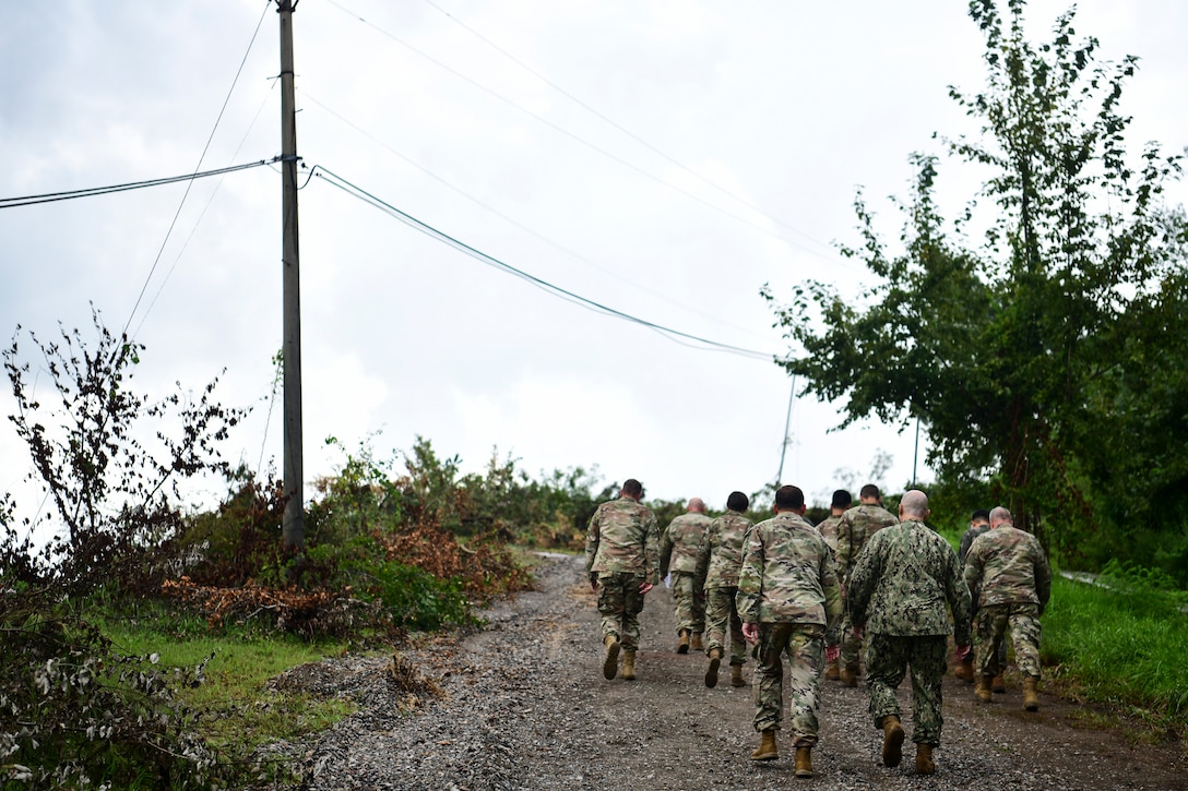 Airmen walk up a hill.