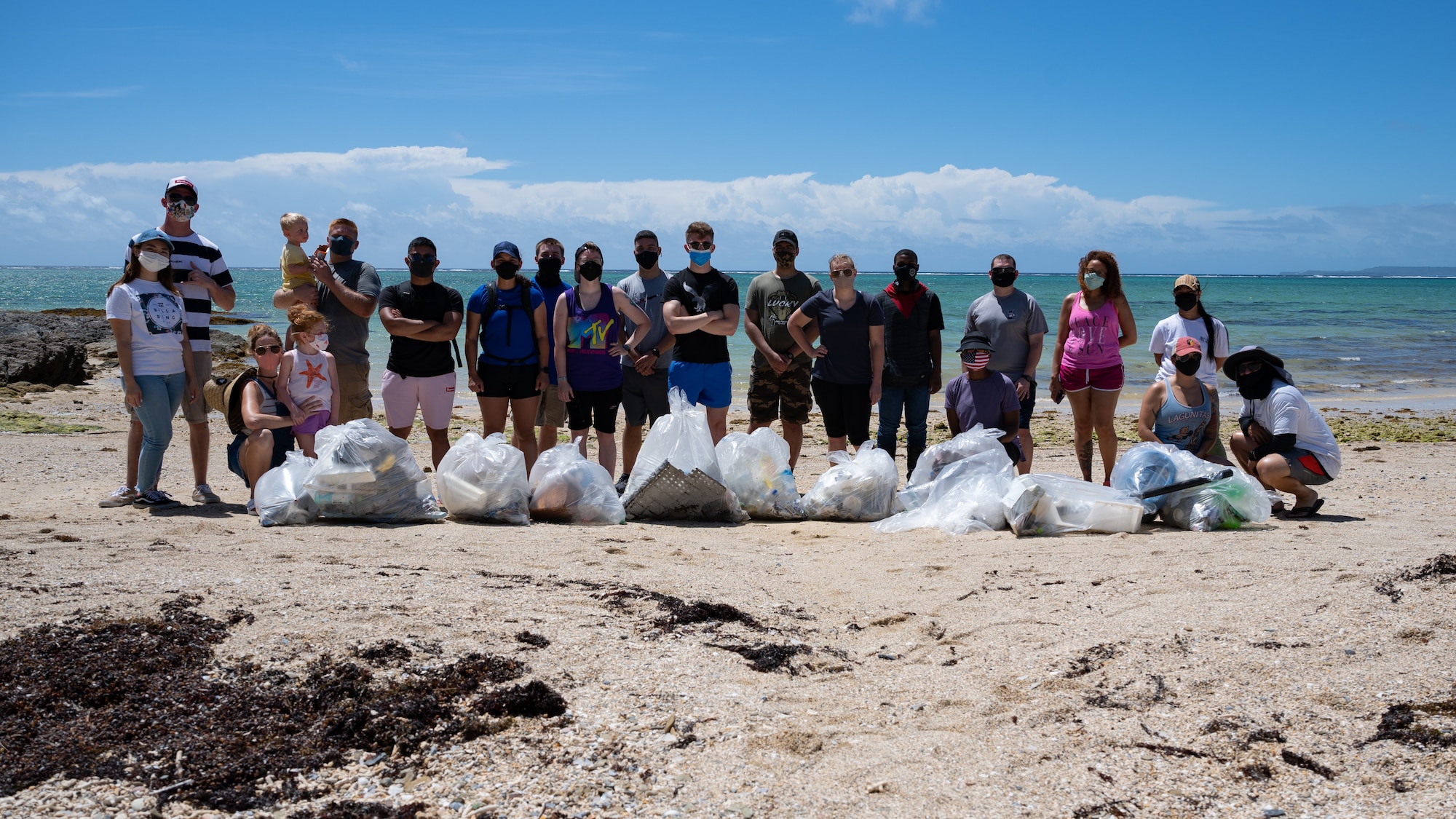 U.S. Air Force Airmen and families from Kadena Air Base come together for a group photo after a volunteer beach clean-up at Seaglass Beach on Okinawa, Japan, Aug. 21, 2021. The Seaglass Beach clean-up was a coordinated effort between Kadena’s Airmen Committed to Excellence program, and the First Sergeants Council. (U.S. Air Force photo by Airman 1st Class Stephen Pulter)
