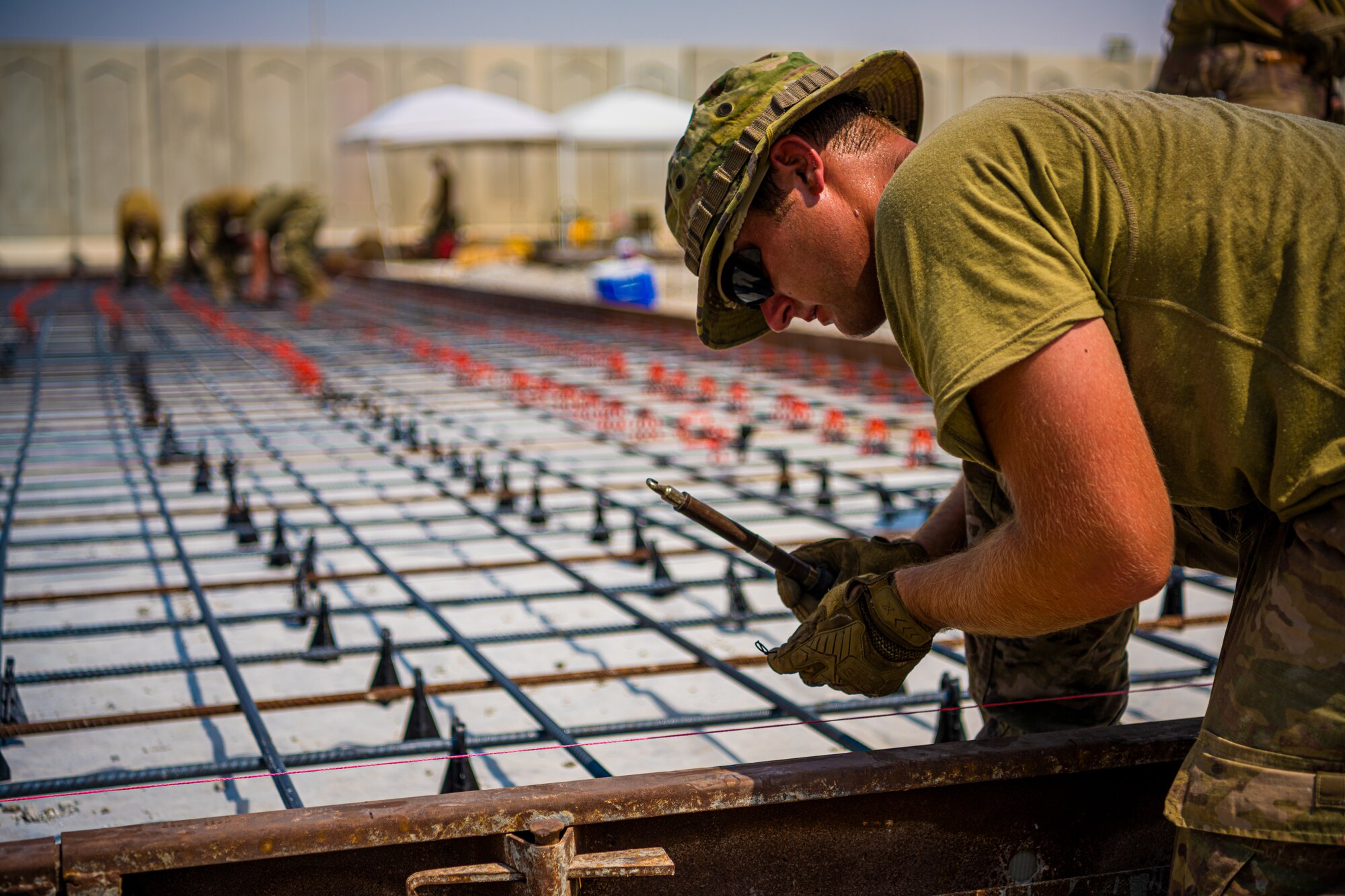 U.S. Air Force Airmen from the 1st Expeditionary Civil Engineer Group (ECEG) and 380th Expeditionary Civil Engineer Squadron lay foundation for expansion at Al Dhafra Air Base, United Arab Emirates, Aug. 18, 2021.