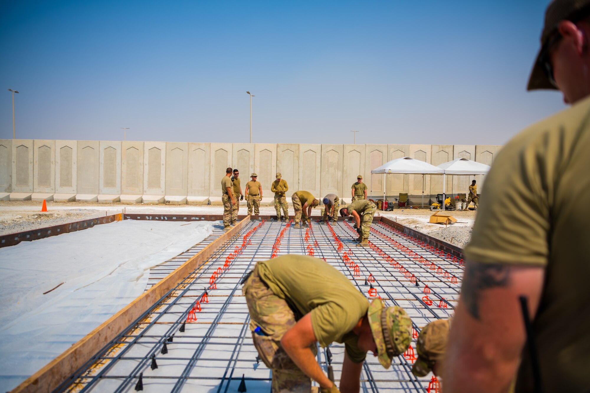 U.S. Air Force Airmen from the 1st Expeditionary Civil Engineer Group (ECEG) and 380th Expeditionary Civil Engineer Squadron lay foundation for expansion at Al Dhafra Air Base, United Arab Emirates, Aug. 18, 2021.