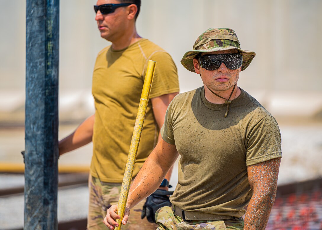 U.S. Air Force Airmen from the 1st Expeditionary Civil Engineer Group (ECEG) and 380th Expeditionary Civil Engineer Squadron lay foundation for expansion at Al Dhafra Air Base, United Arab Emirates, Aug. 18, 2021.