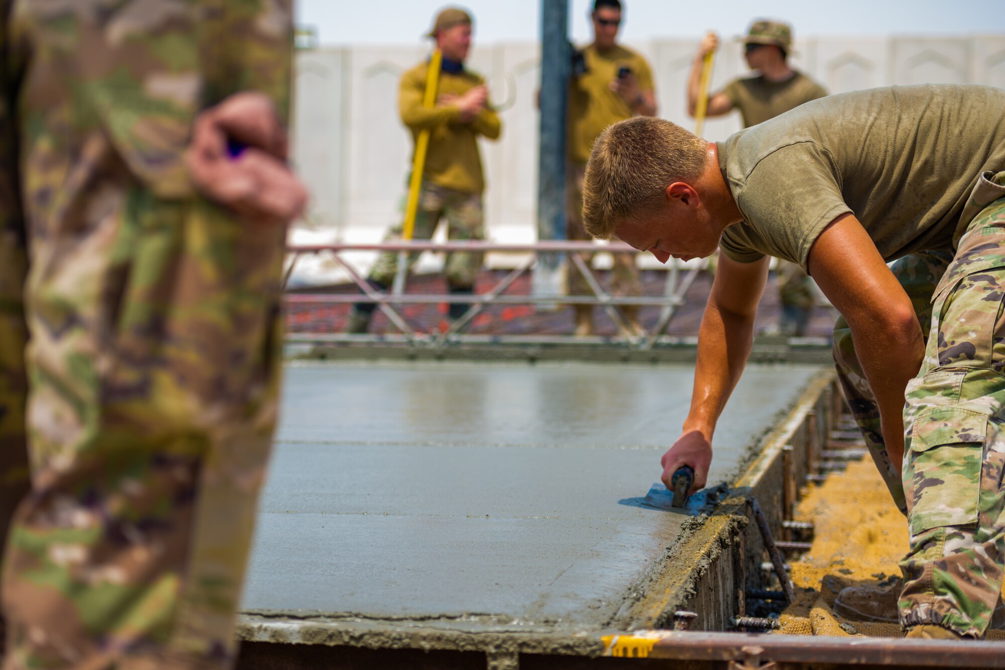 U.S. Air Force Airmen from the 1st Expeditionary Civil Engineer Group (ECEG) and 380th Expeditionary Civil Engineer Squadron lay foundation for expansion at Al Dhafra Air Base, United Arab Emirates, Aug. 18, 2021.