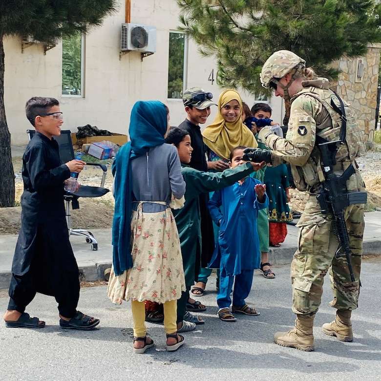 A  platoon leader with the Minnesota National Guard's A Company, 1st Combined Arms Battalion, 194th Armor Regiment, U.S. Army Central, interacts with Afghan children as part of operations at Hamid Karzai International Airport on August 21, 2021.   Minnesota Soldiers are providing humanitarian assistance to U.S. citizens, special immigrant visa holders, and their families. (Minnesota National Guard photo by Army Capt. Vincent Struble)