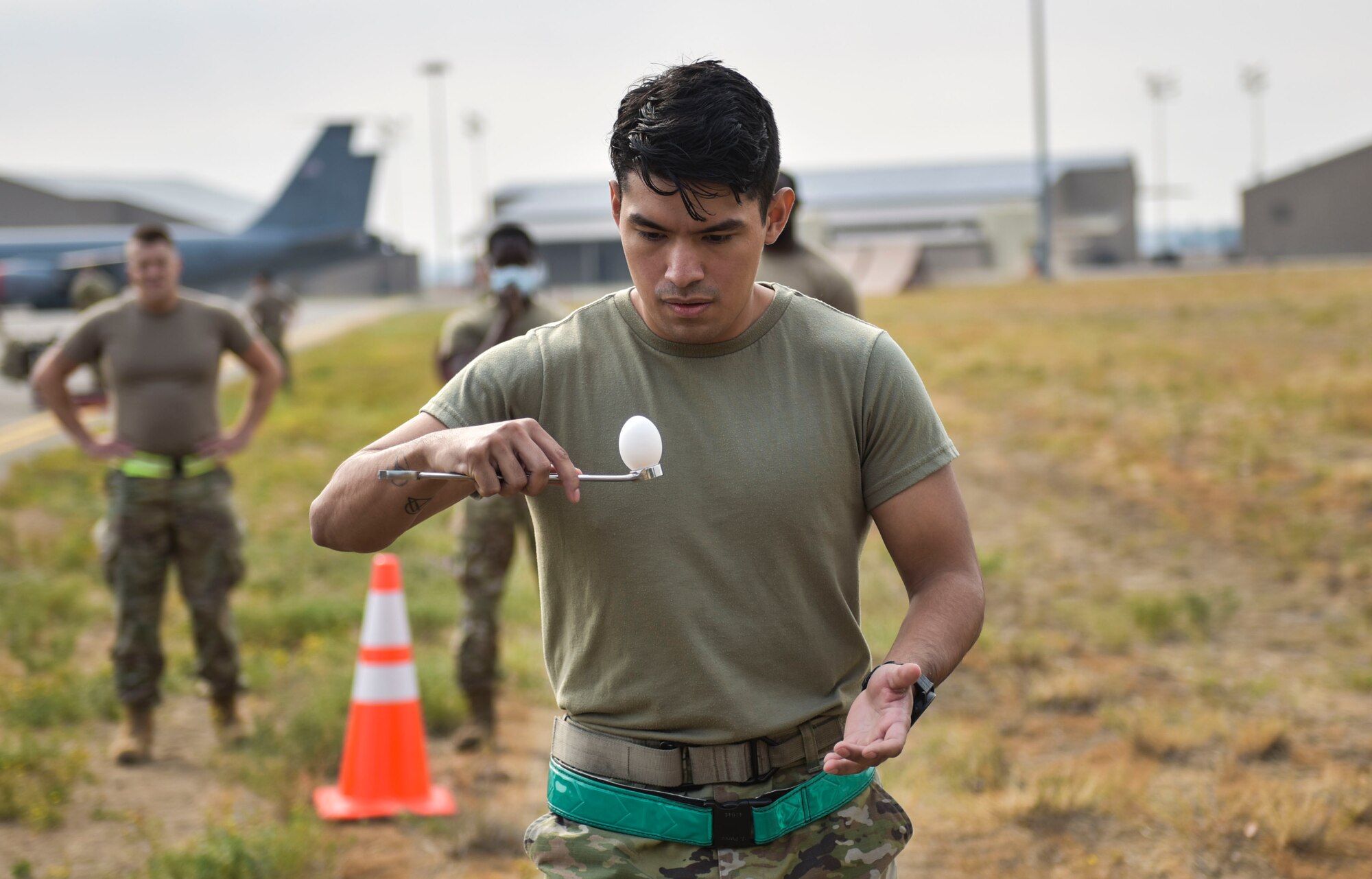 U.S. Air Force Senior Airman Joel N. Perez, 92nd Aircraft Maintenance Squadron Communication Navigation Mission Systems Journeyman, carries an egg on a wrench during an egg relay race at the Maintenance Olympics event at Fairchild Air Force Base, Washington, Aug. 20, 2021.