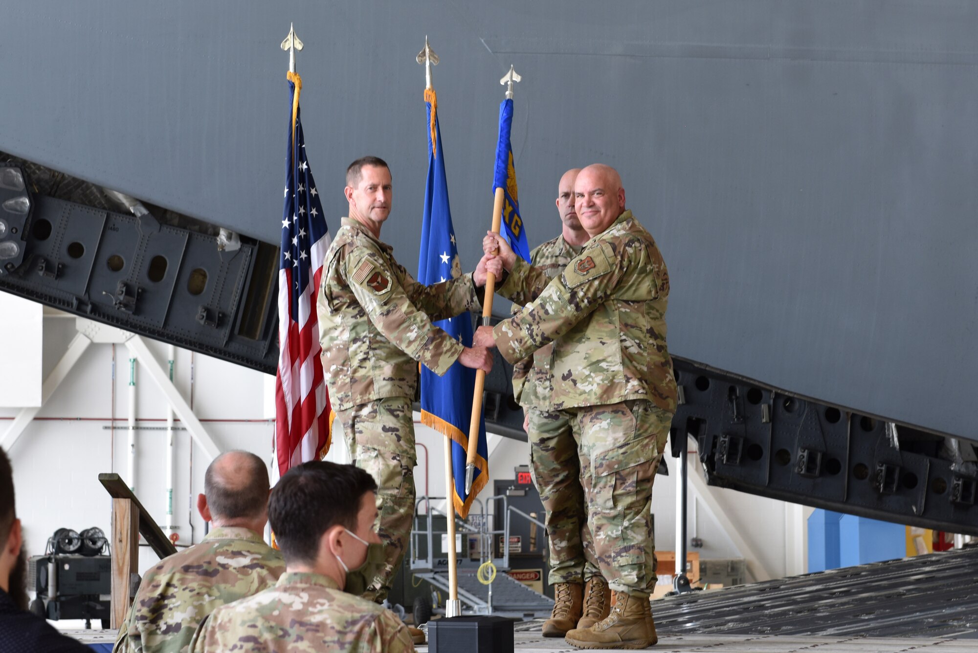 Col. John F. Robinson, 911th Airlift Wing commander, passes the 911th Maintenance Group guidon to Lt. Col. Richard Cox, 911th MXG commander, at the Pittsburgh International Airport Air Reserve Station, Pennsylvania, Aug. 8, 2021. The passing of the guidon symbolizes the transfer of command and that Cox assumes responsibility for the 911th Maintenance Group.