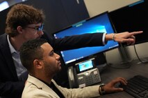 Ethan Marshall (left) and Jimmy Rodriguez, U.S. Air Force Premier College Interns, collaborate at U.S. Cyber Command, Fort George G. Meade, Md., Aug. 18, 2021.