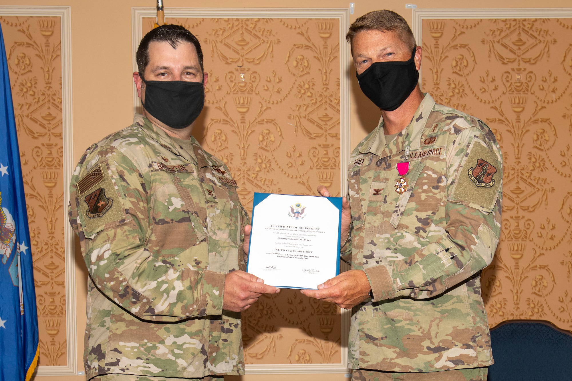 Col. Christopher G. Batterton, 192nd Wing commander, left, and Col. Jason R. Price, outgoing 192nd Medical Group commander, pose for a photo holding Price's certificate of retirement.