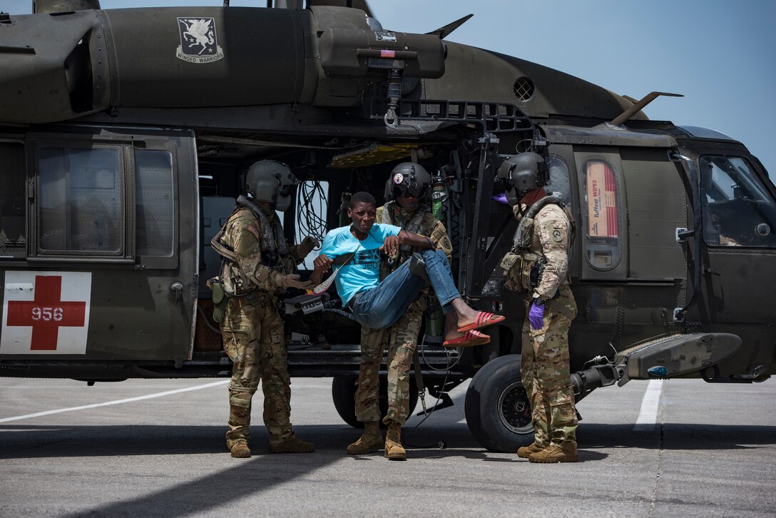 U.S. Soldiers with the 1st Battalion, 228th Aviation Regiment, Joint Task Force-Bravo, Soto Cano Air Base, Honduras, unload patients from a UH-60 Black Hawk helicopter during a medical evacuation mission in Port-au-Prince, Haiti, Aug. 24, 2021.