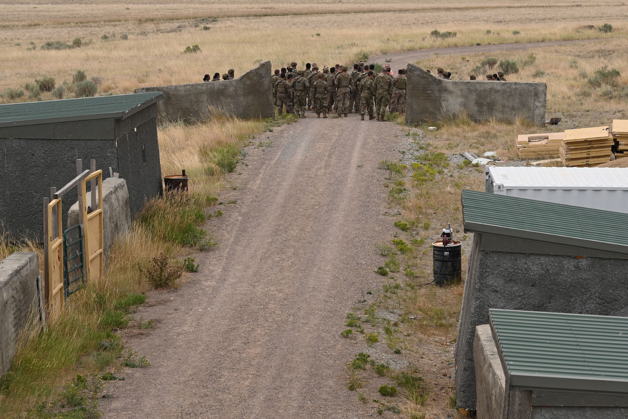 Defenders from the 841st Missile Security Forces Squadron gather for a briefing before beginning a breaching exercise Aug. 17, 2021, at the firing range village on Fort Harrison, Mont. The village is designed to simulate a real-world environment that defenders may find themselves in when confronted by enemy combatants. (U.S. Air Force photo by Airman Elijah Van Zandt)