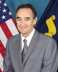 Portrait of Brett Hamilton (SSTM), NSWC Crane in front of an American flag.