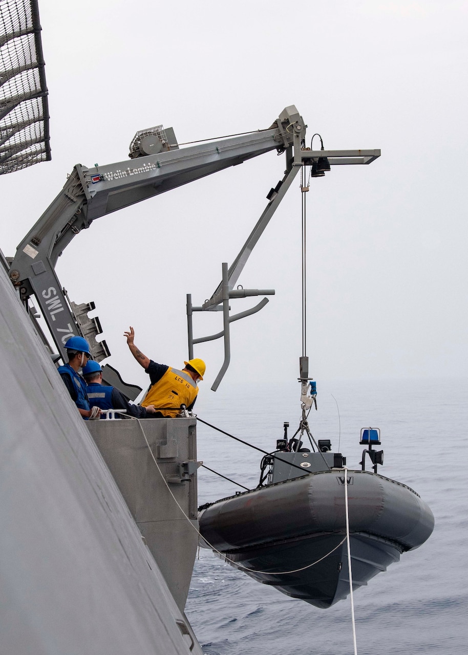 Sailors lower a rigid-hulled inflatable boat to the side of Independence-variant littoral combat ship USS Charleston (LCS 18) during boat operations, Aug. 18.