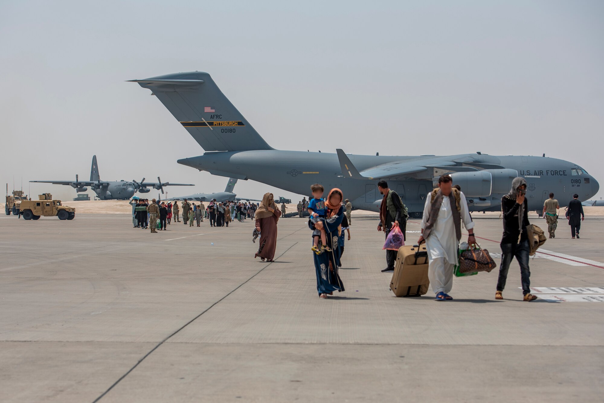 Qualified evacuees debark a C-17 Globemaster lll Aug. 23, 2021, at Al Udeid Air Base, Qatar.