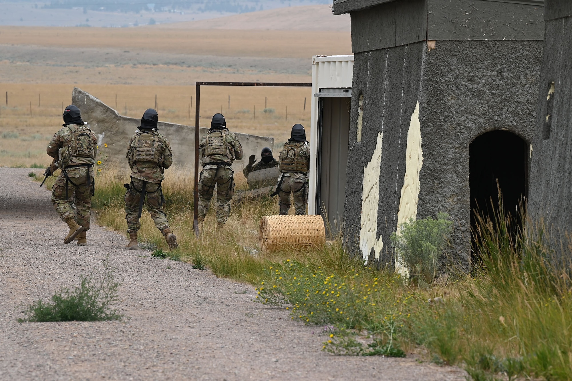 Defenders from the 841st Missile Security Forces Squadron navigate through a mock village during a training exercise Aug. 17, 2021, at the firing range on Fort Harrison, Mont. The exercise concluded with the simulated enemy combatants’ surrender, resulting from the unity and precision. (U.S. Air Force photo by Airman Elijah Van Zandt)