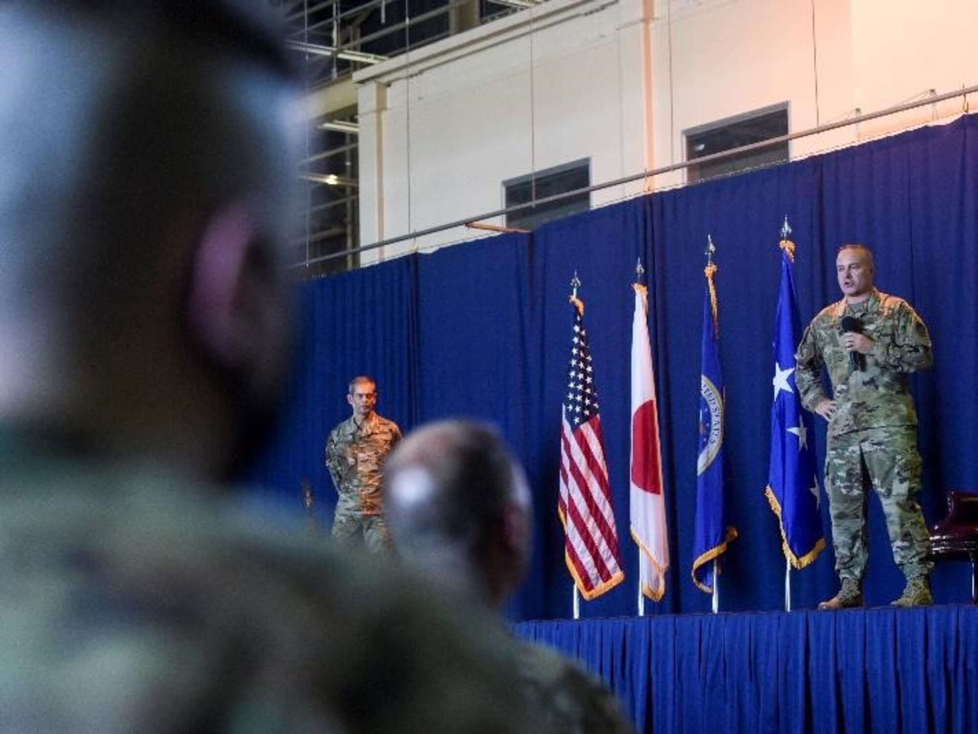 Service members listen to another service member address audience.