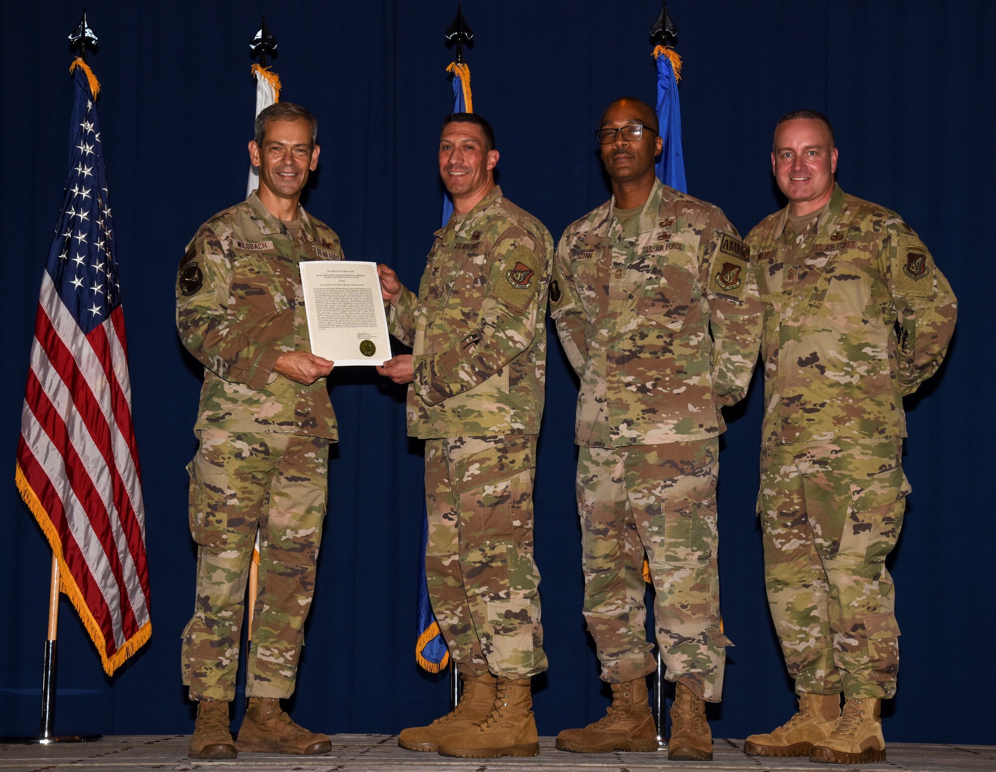 Service members receive an award and pose for a photo.