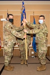 Col. Christopher G. Batterton, 192nd Wing commander, left, passes the 192nd Medical Group guidon to Col. Frank Y. Yang marking his assumption of command for the group.